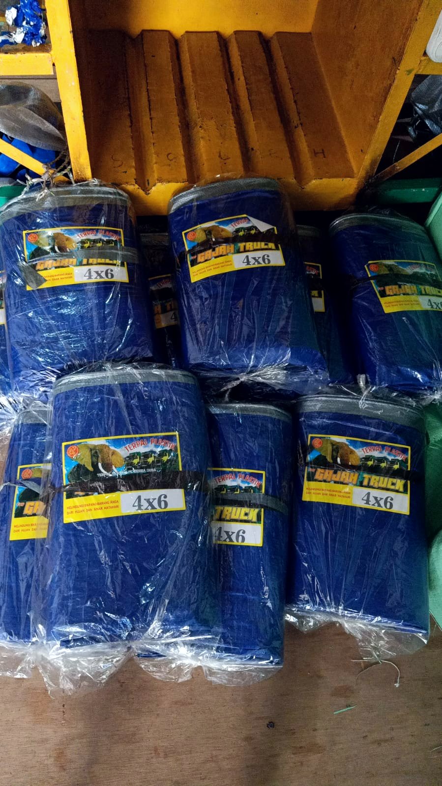 Tumpukan terpal plastik lembaran biru ukuran 4×6 m masih dalam kemasan plastik